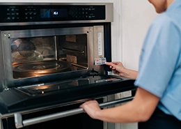 Mr. Appliance tech putting a sticker on an oven.