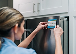 Mr. Appliance tech putting a sticker on a refrigerator.